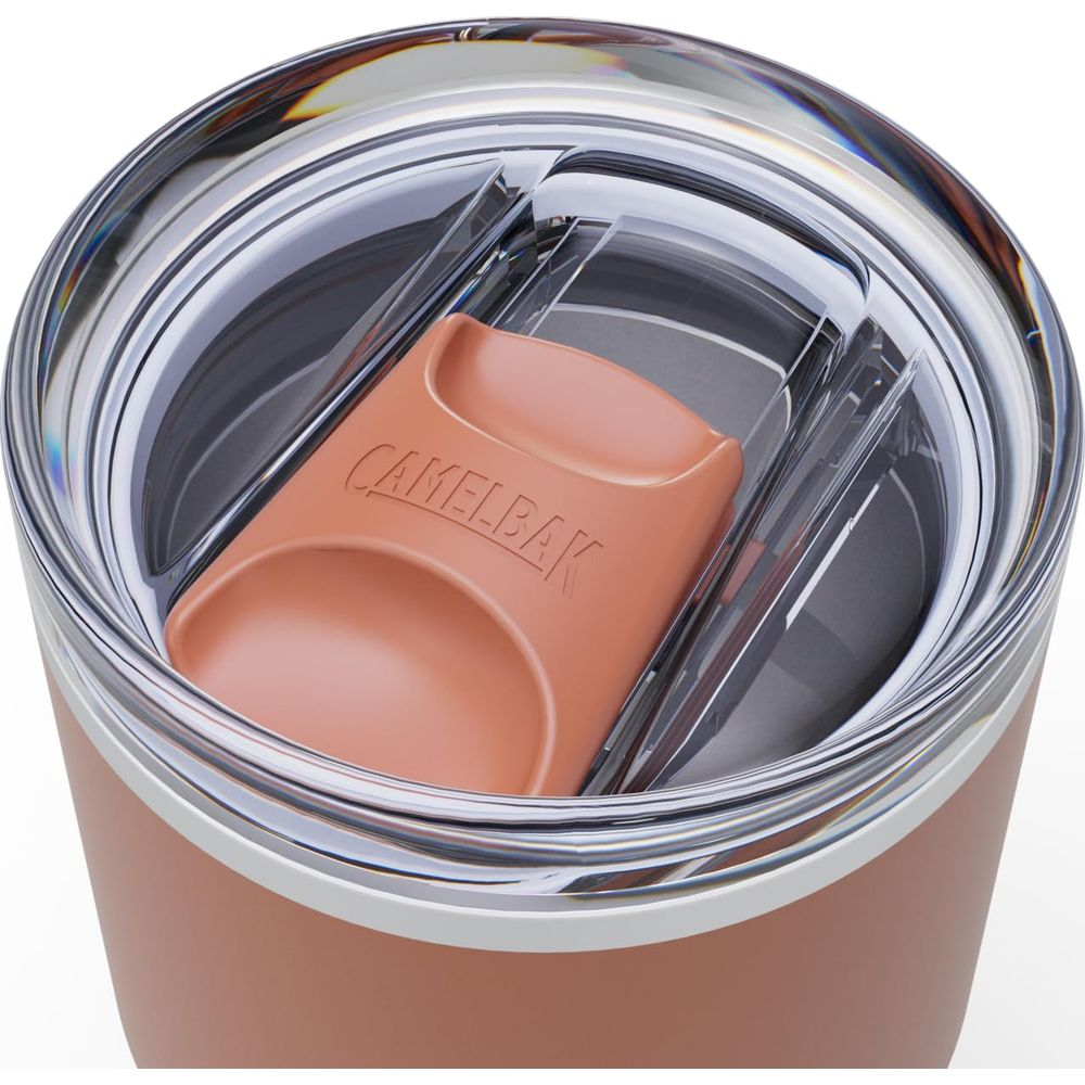 Nahaufnahme des Deckels eines roséfarbenen Bechers mit klarer Plastikabdeckung und braunem Camelbak-Logo.