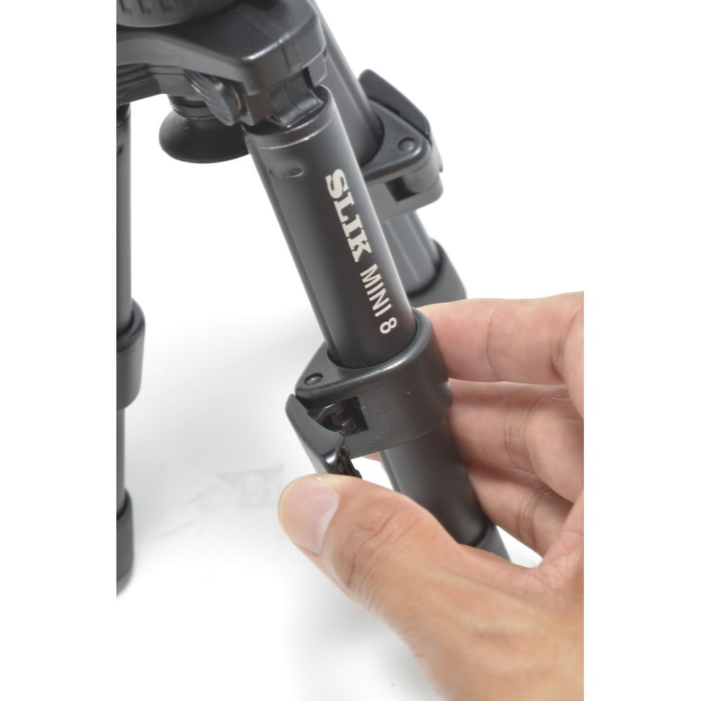 Main ajustant une jambe de trépied Slik Mini 8 noire.