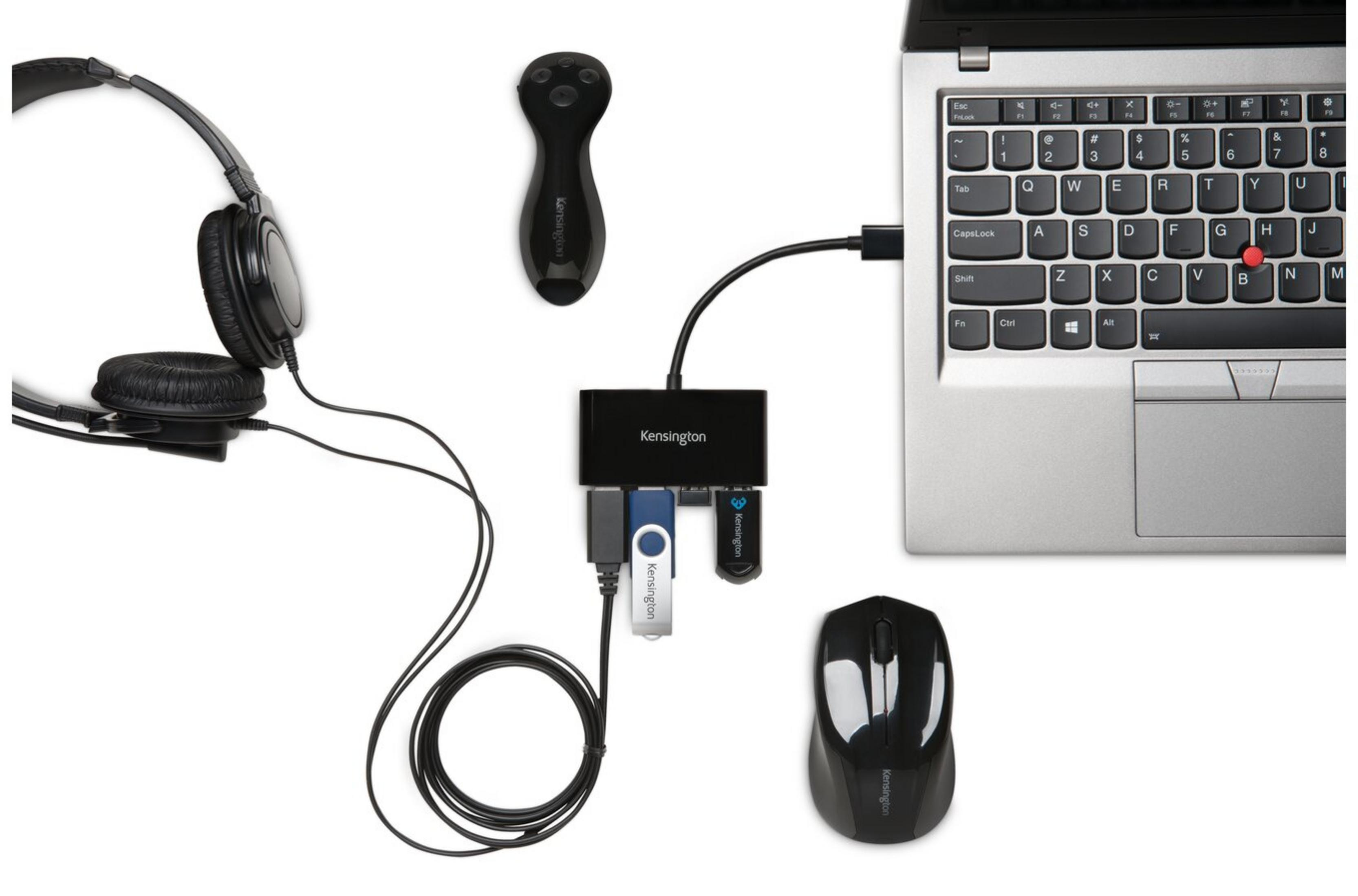 Cuffie, mouse, hub USB e laptop disposti su sfondo bianco.