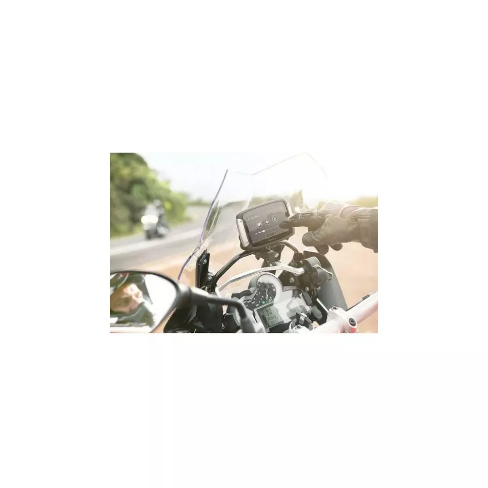 Fahrer mit Handschuhen bedient Navi auf einem Motorrad. Eine weitere Maschine ist im Hintergrund.
