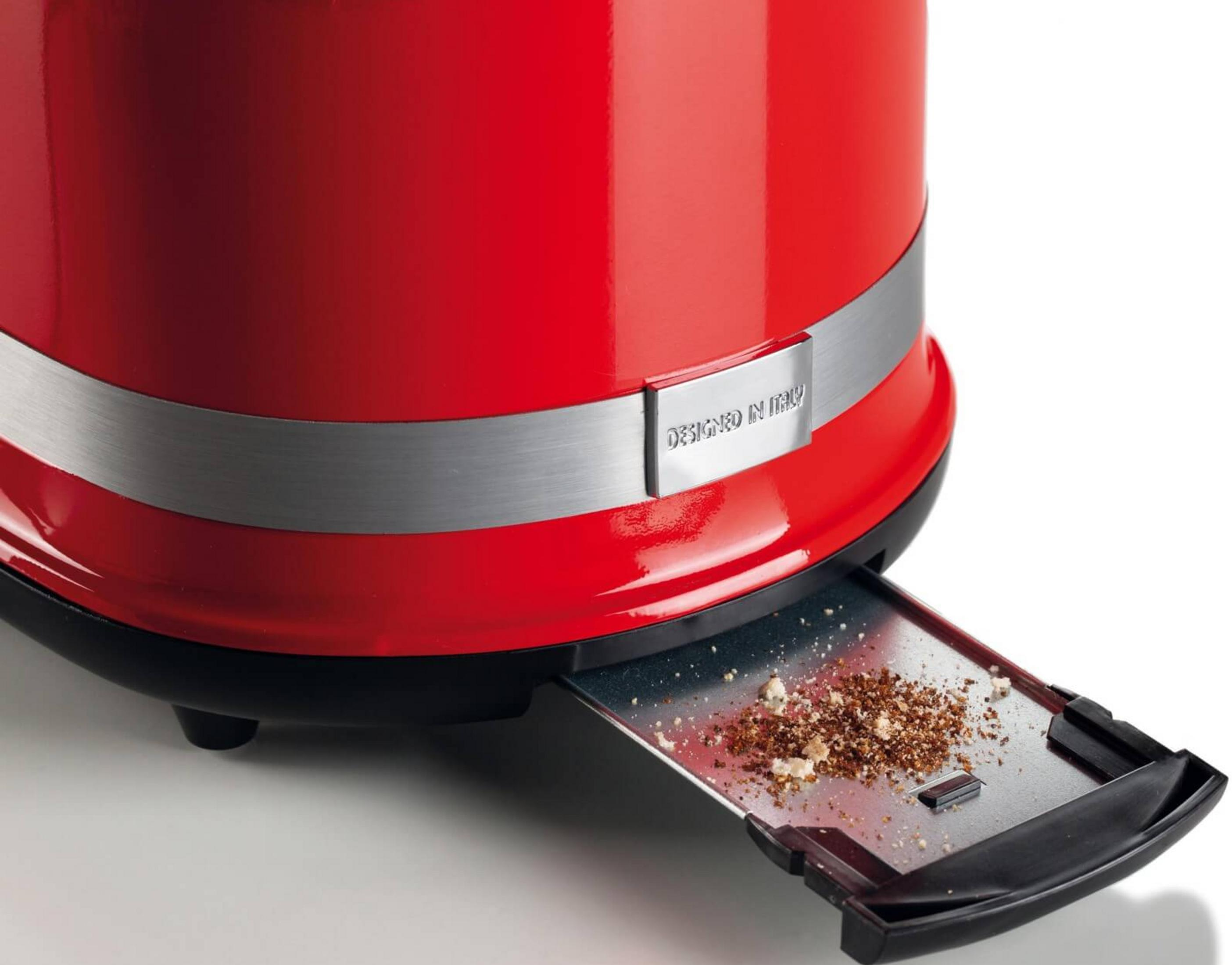 Czerwony toster z tacką na okruchy pełną okruchów.