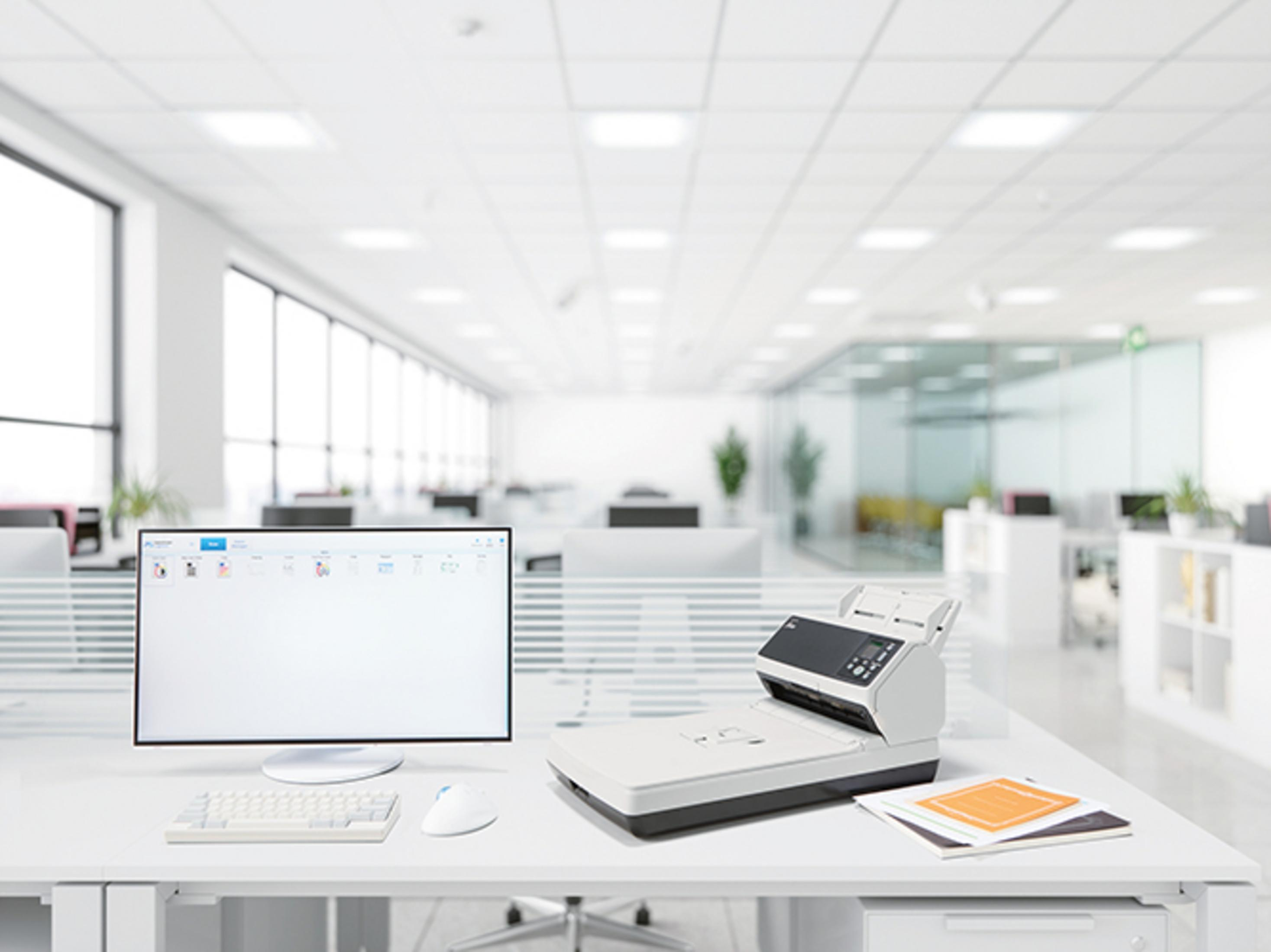 Nowoczesny skaner biurowy i monitor na biurku w jasnym biurze.