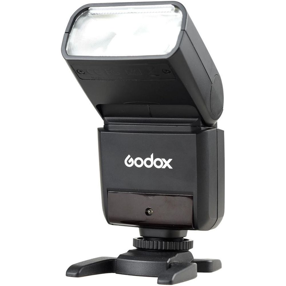 Czarna lampa błyskowa Godox z białym logo stoi na czarnym statywie.