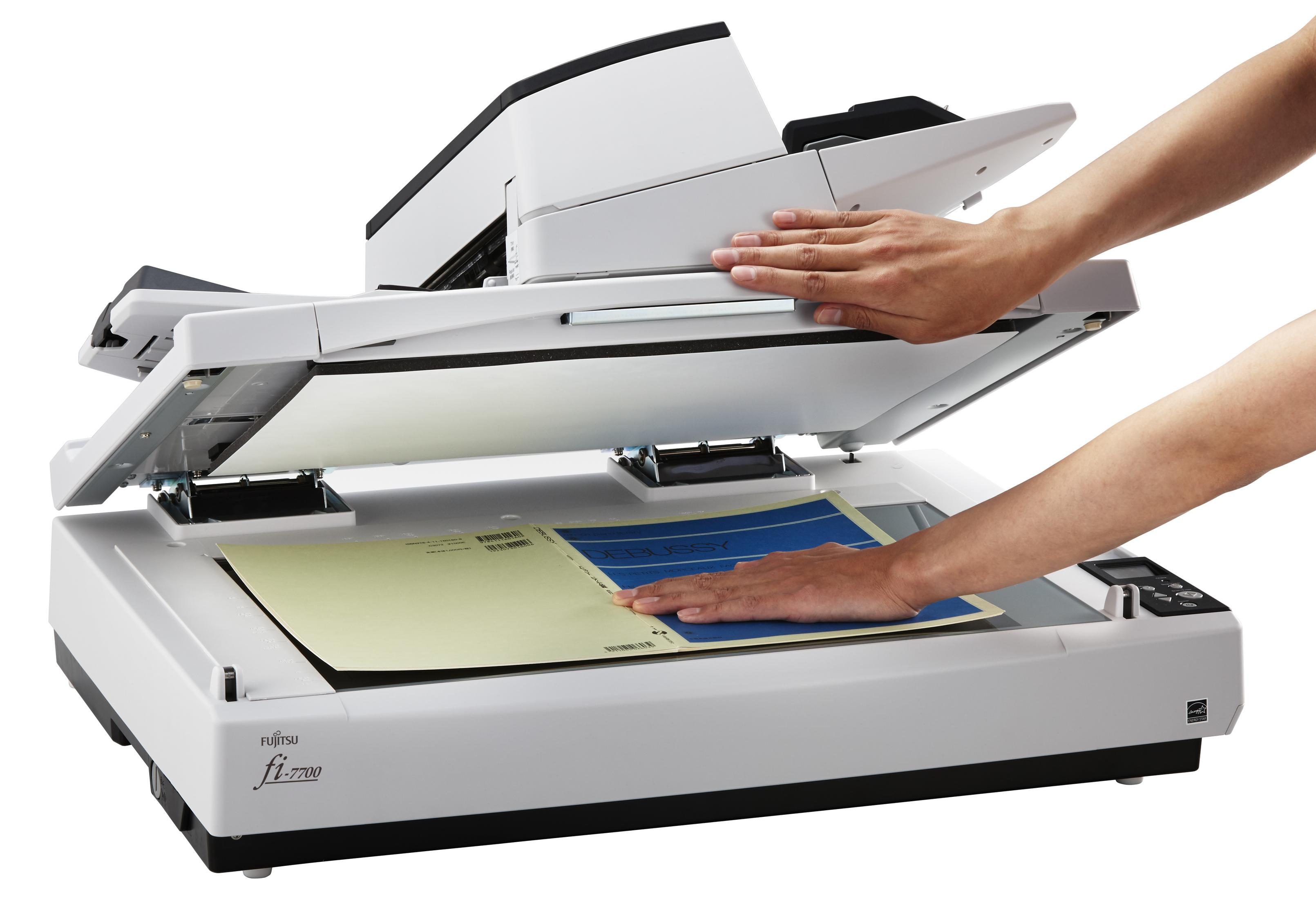 Due mani azionano uno scanner Fujitsu, scansionando documenti.
