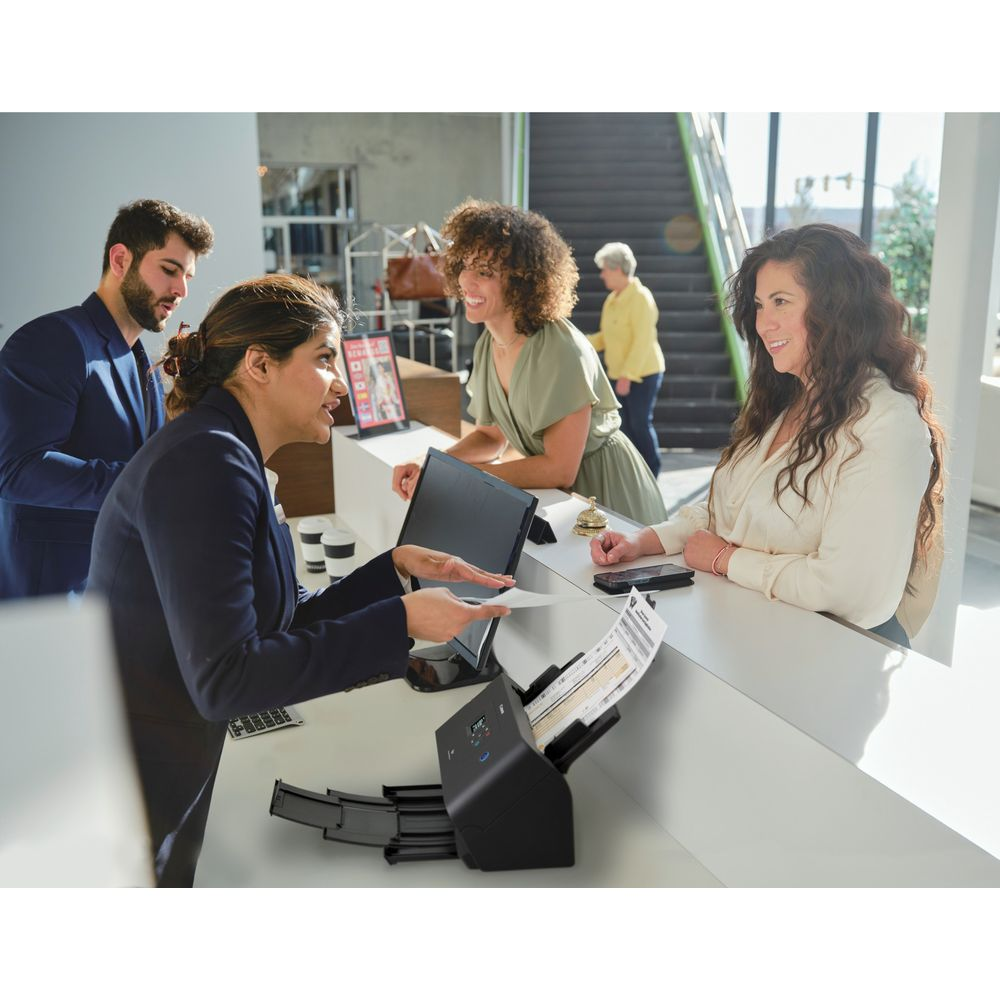 Recepcjonistka skanuje dokumenty dla klientów przy ladzie.