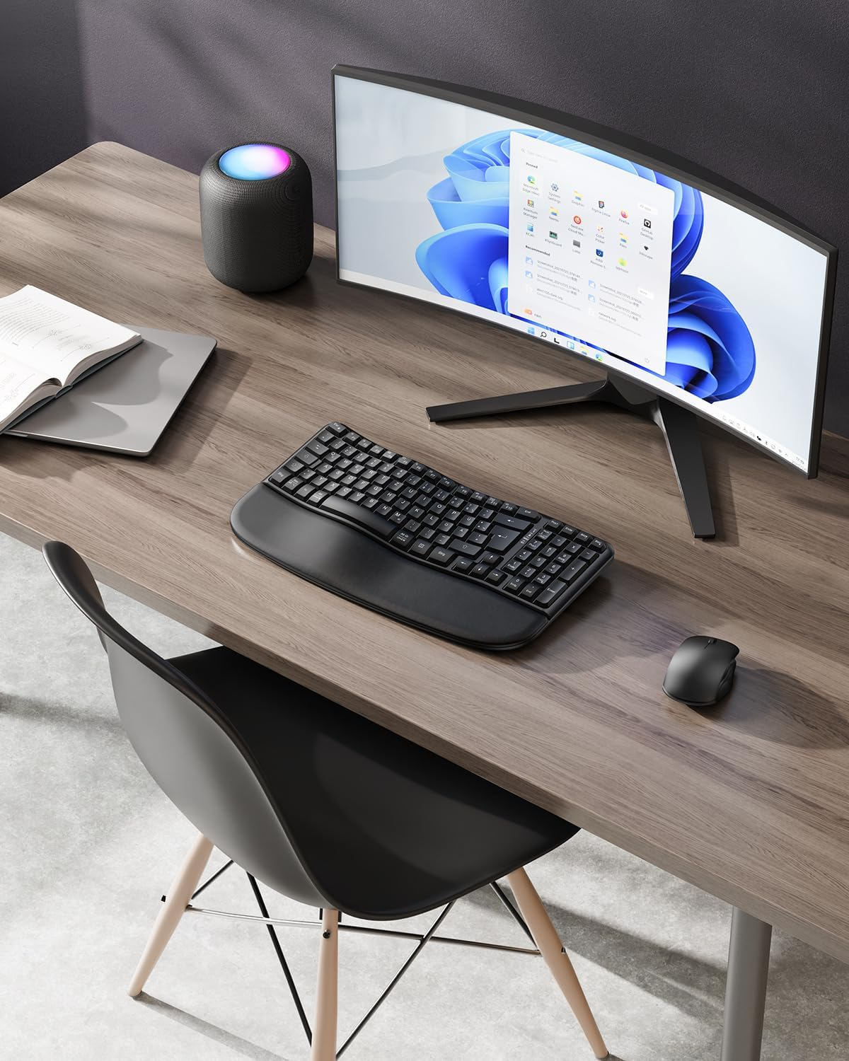 Biurko z monitorem, klawiaturą, myszką, głośnikiem, książką i krzesłem.