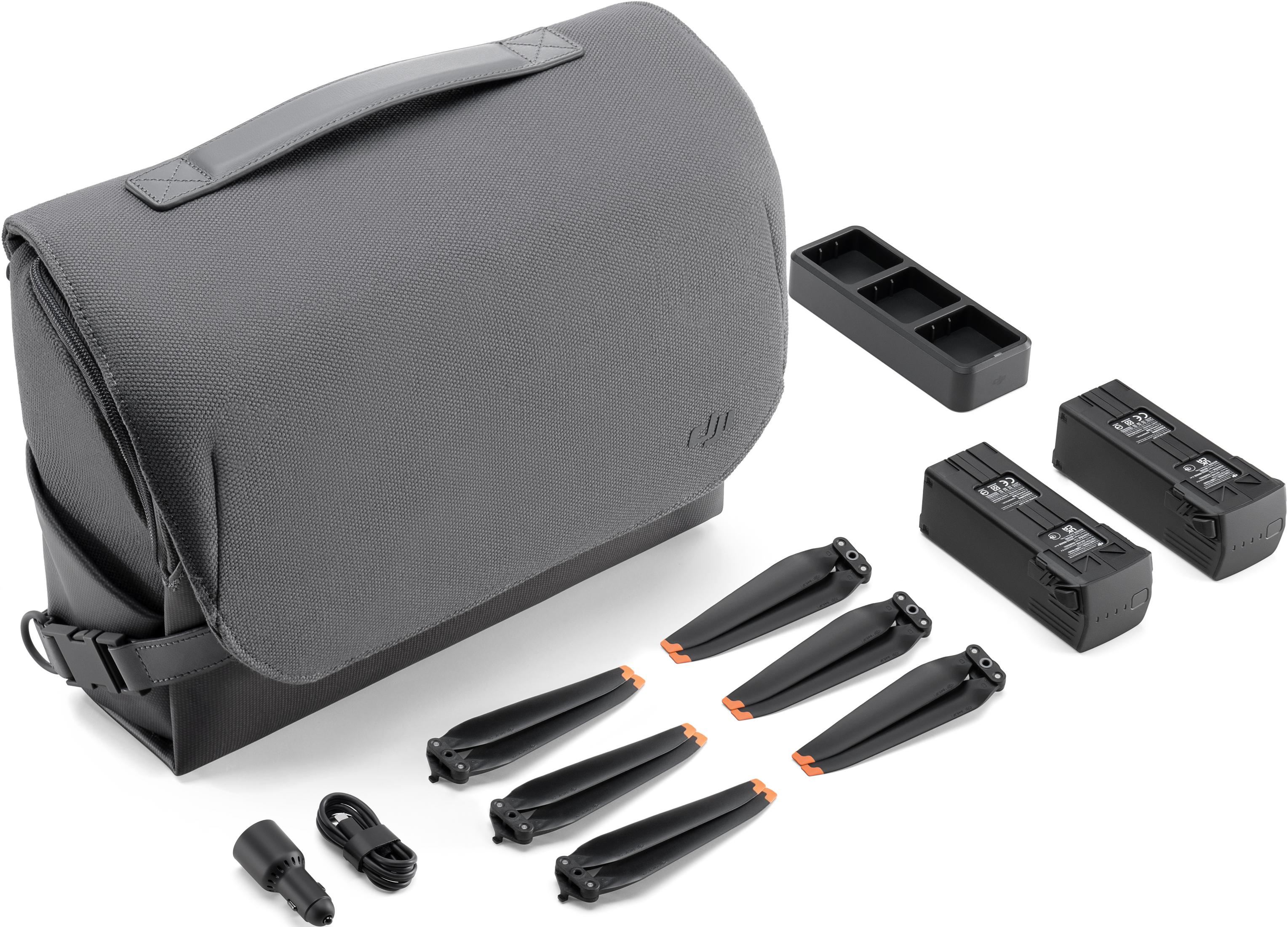 Szara torba z akcesoriami do drona: śmigła, baterie, ładowarka i kable.