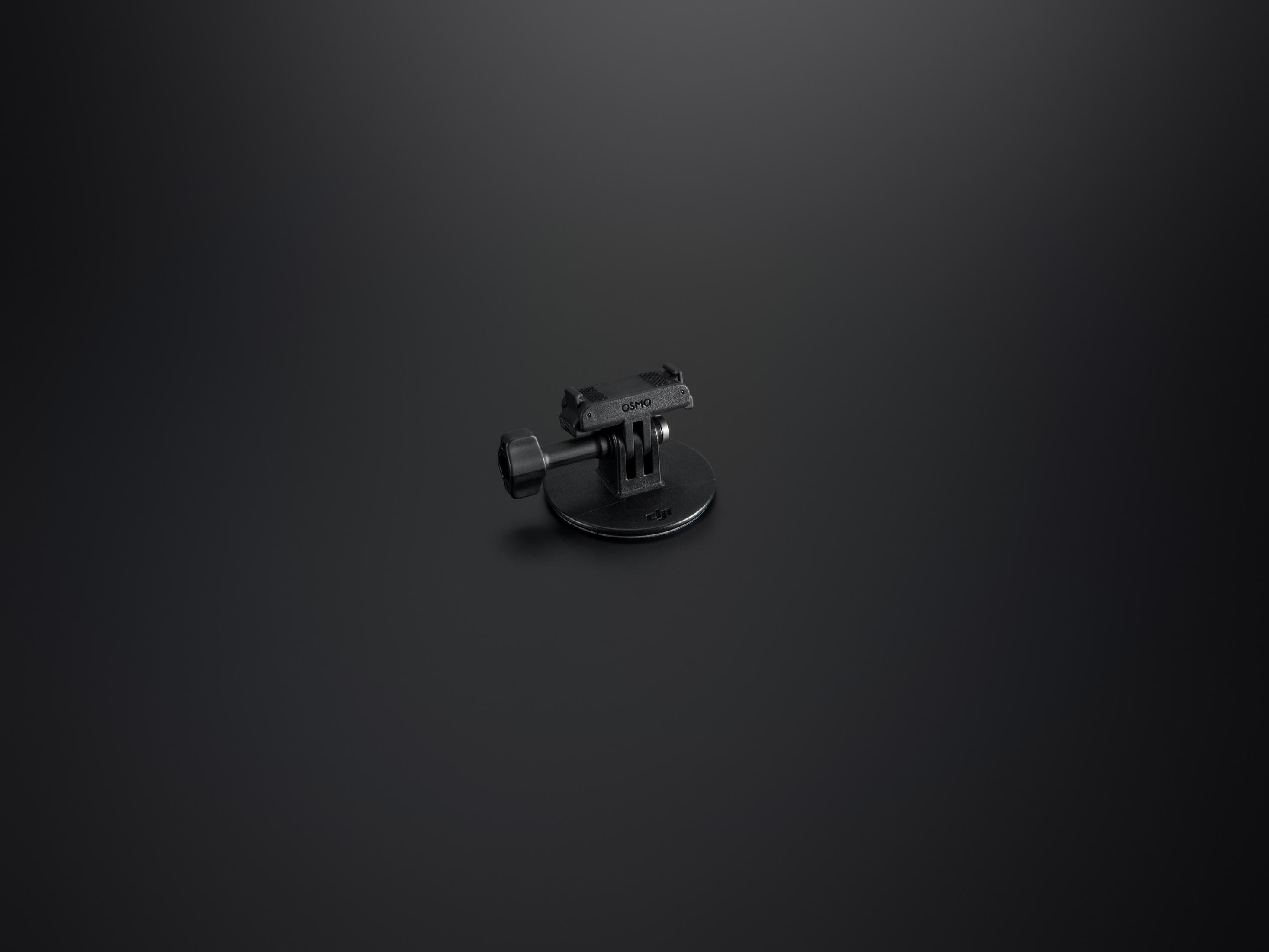 Un support OSMO noir avec un bouton moleté sur fond sombre.