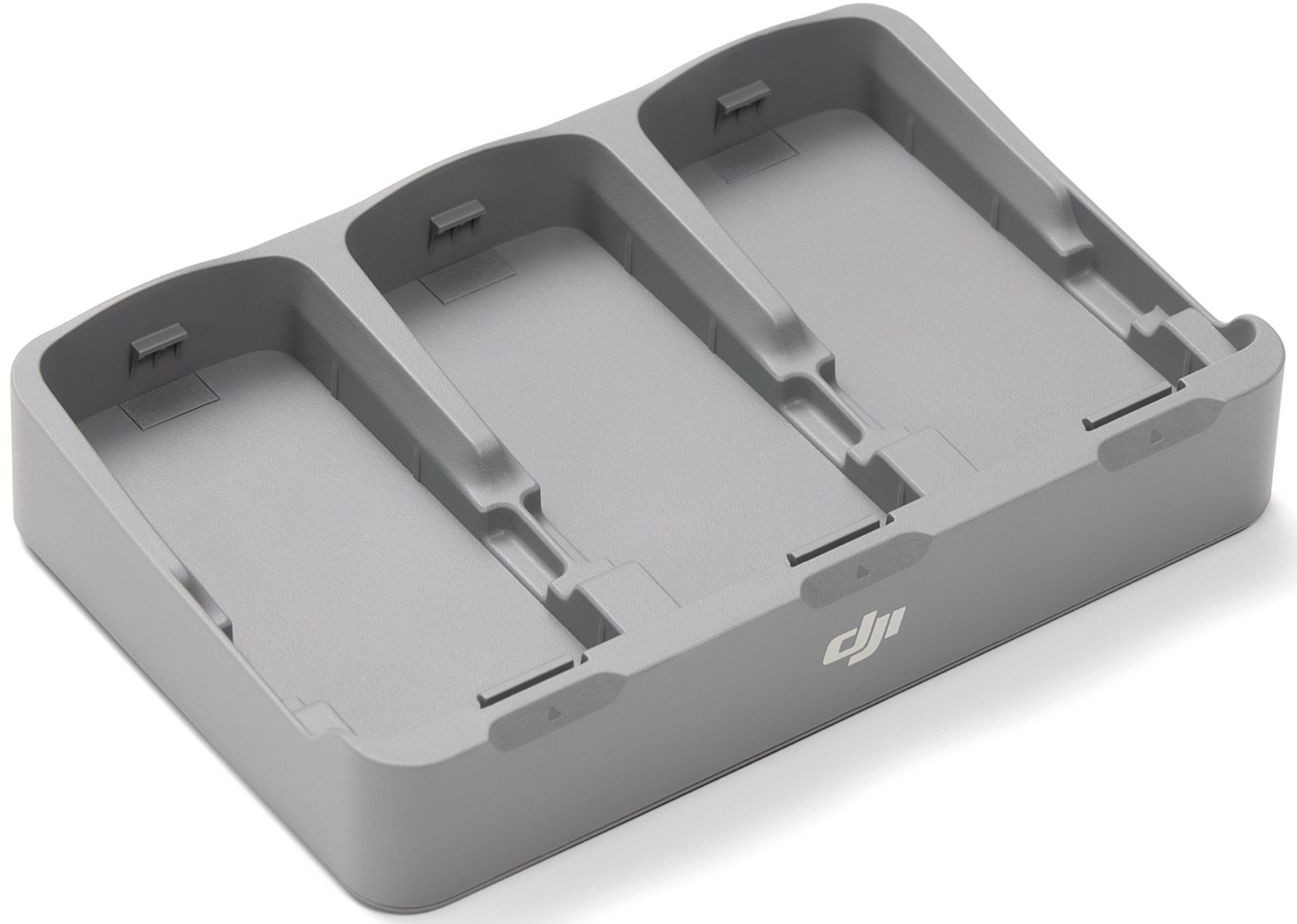 Dock di ricarica grigio per tre batterie con logo DJI, isolato su sfondo bianco.