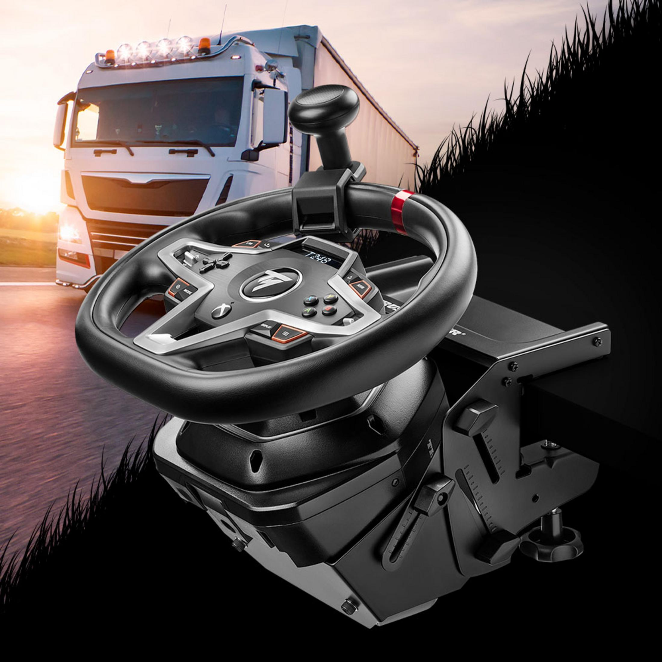 Symulator kierownicy wyścigowej z ciężarówką w tle o zachodzie słońca.