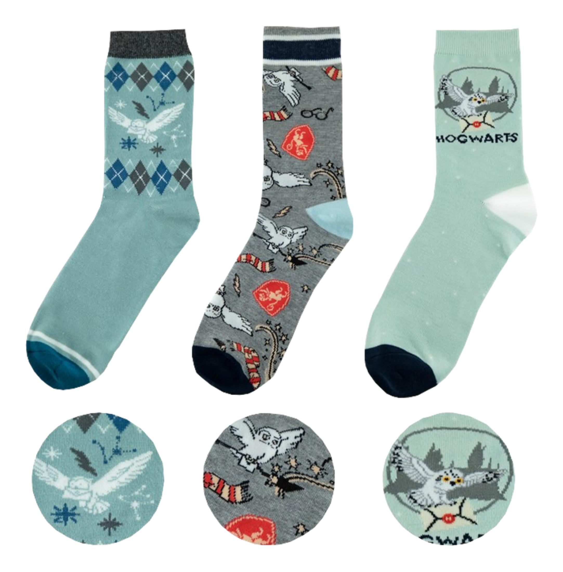 Drei Paar Harry Potter Socken mit Eulen- und Hogwarts-Motiven.