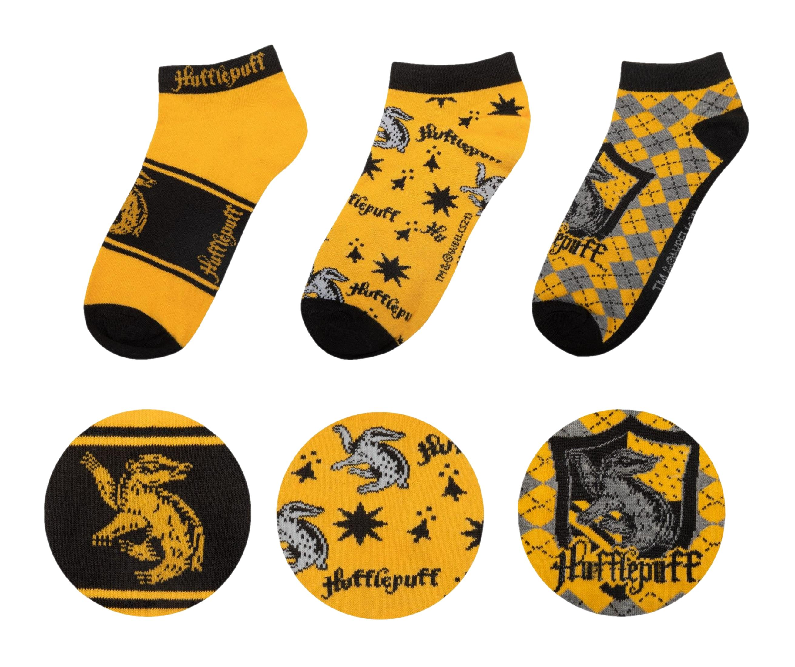 Drei Hufflepuff-Socken mit gelben, schwarzen und grauen Mustern.