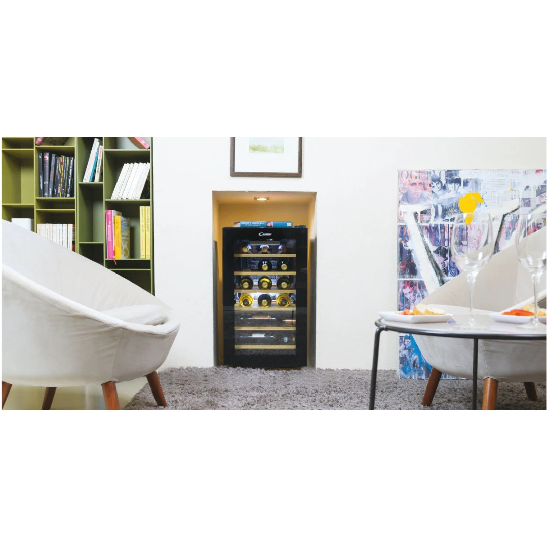 A wine fridge in a niche between two armchairs and a table.