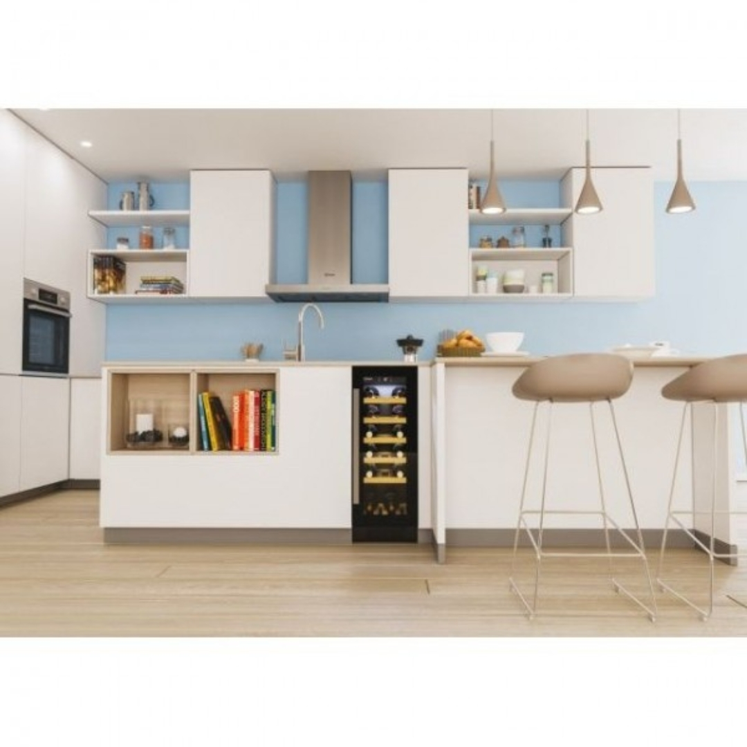 Modern kitchen with wine cooler, books, and bar stools against blue wall.