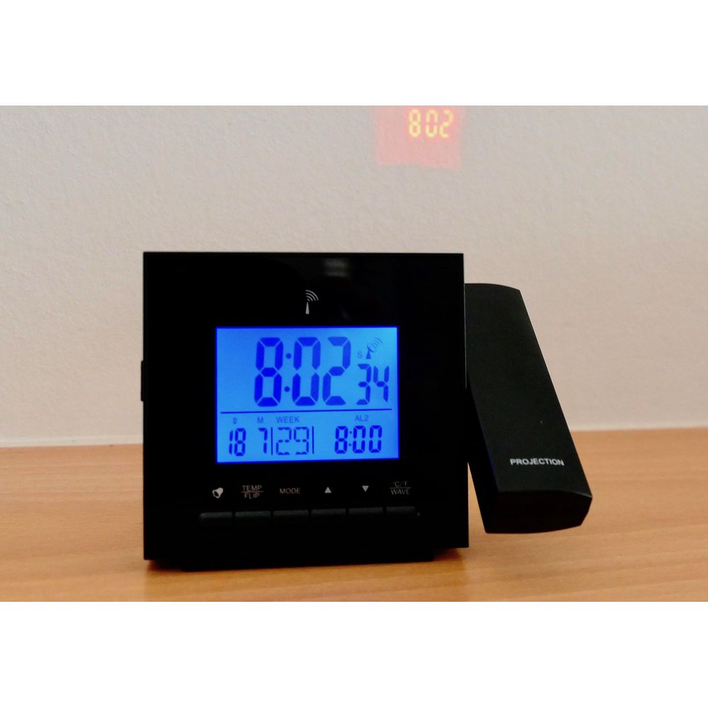 Ein schwarzer Digitalwecker mit blauem Display projiziert die Zeit an eine Wand.