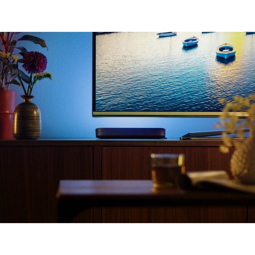 Une TV affichant des bateaux sur l'eau est encadrée par une lumière bleue.