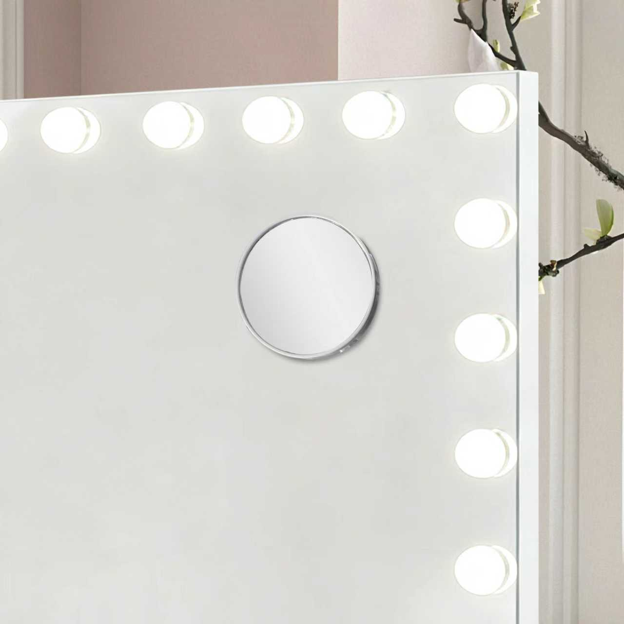 Witte kaptafelspiegel met lampjes en een kleine ronde spiegel.