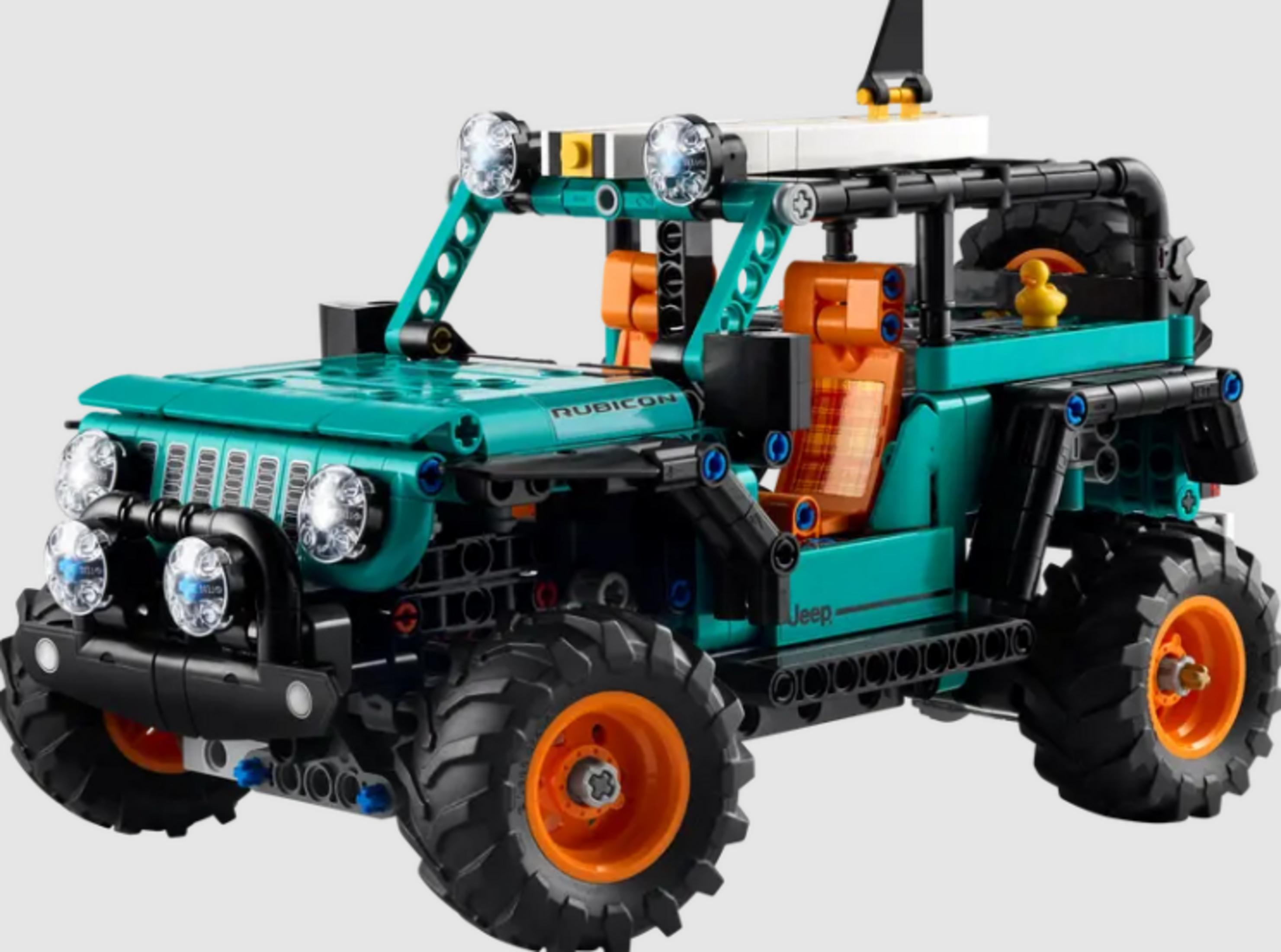Turkusowy Jeep Lego z pomarańczowymi siedzeniami i dużymi oponami.