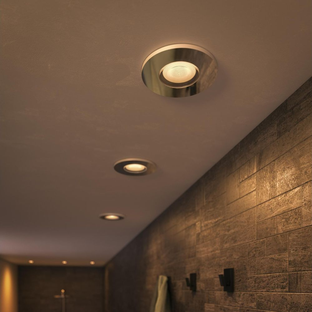Meerdere inbouwspots verlichten een kamer met bakstenen muur vanaf het plafond.