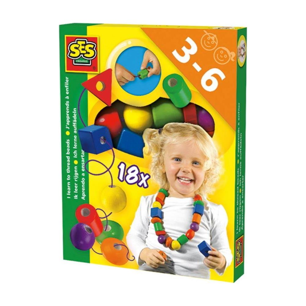 Bambina con collana di perline colorate su scatola giocattolo con perline.