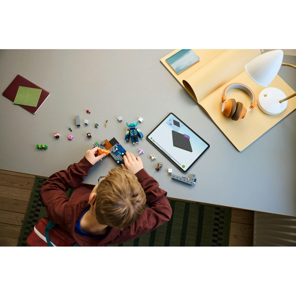 Chłopiec buduje z kolorowych klocków LEGO. Tablet pokazuje instrukcje.