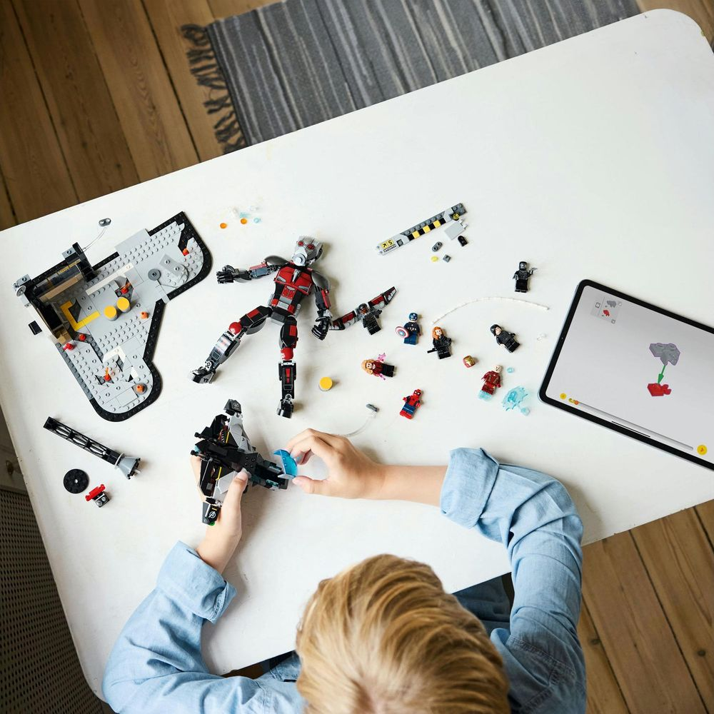 Dziecko buduje z figurek Lego i tabletu pokazującego instrukcje.