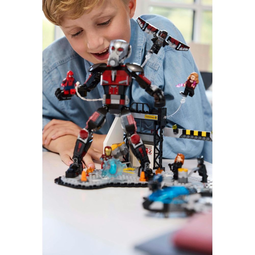 Chłopiec bawi się figurkami Lego Avengers w budynku terminala, Ant-Man pośrodku.