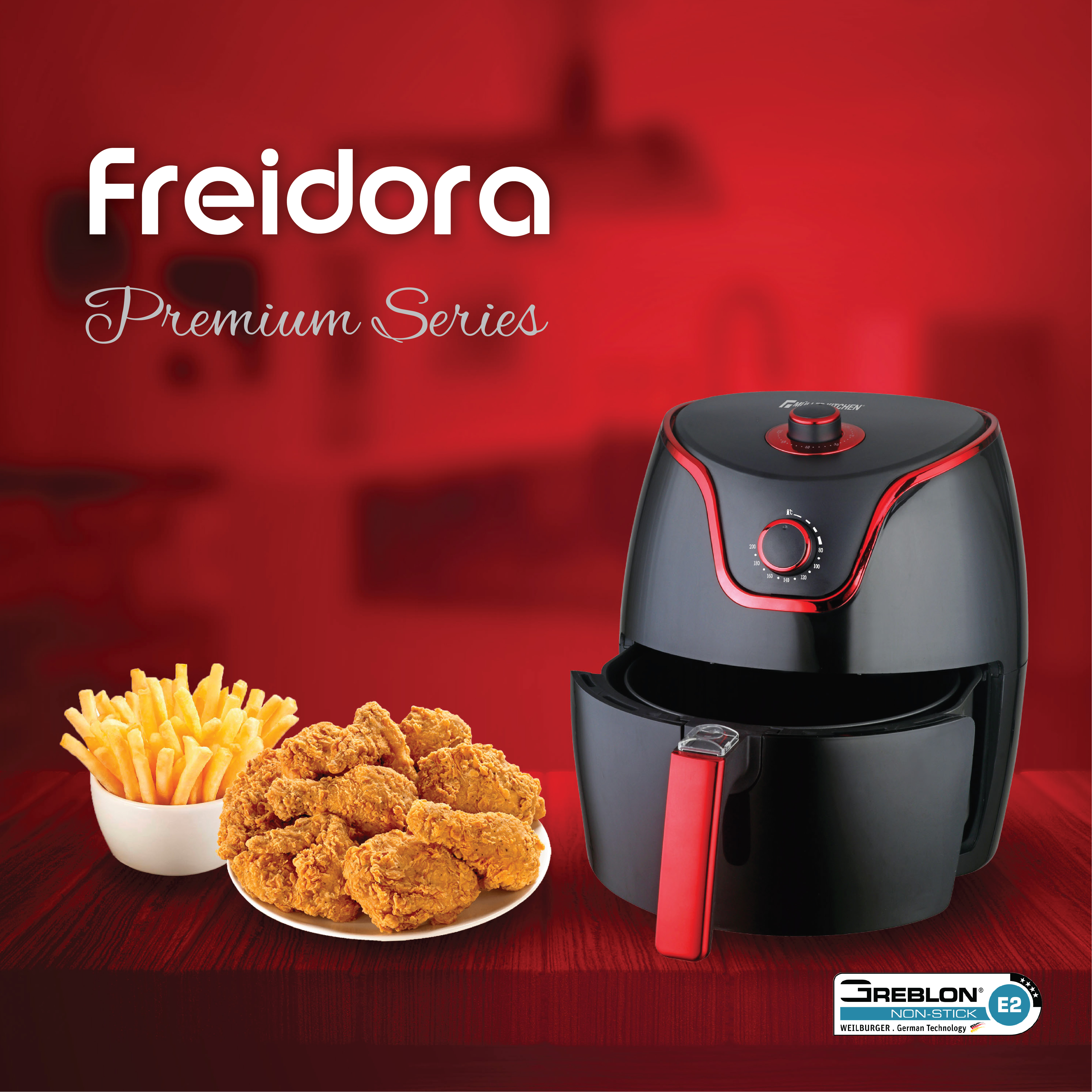 Una freidora de aire negra junto a un plato de pollo frito y un tazón de papas fritas.