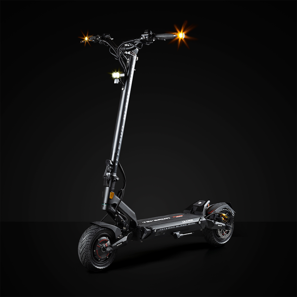 Un scooter électrique noir avec des lumières allumées sur fond noir.