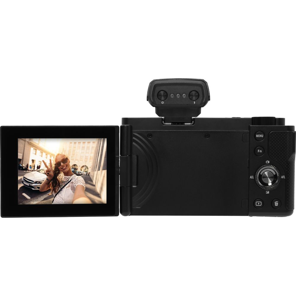 Czarny aparat cyfrowy z odchylanym ekranem pokazującym kobietę robiącą selfie.