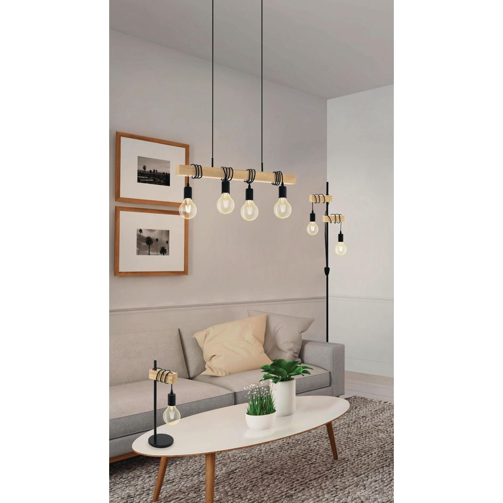 Ein Wohnzimmer mit Sofa, Couchtisch, Lampe und Bilderrahmen.