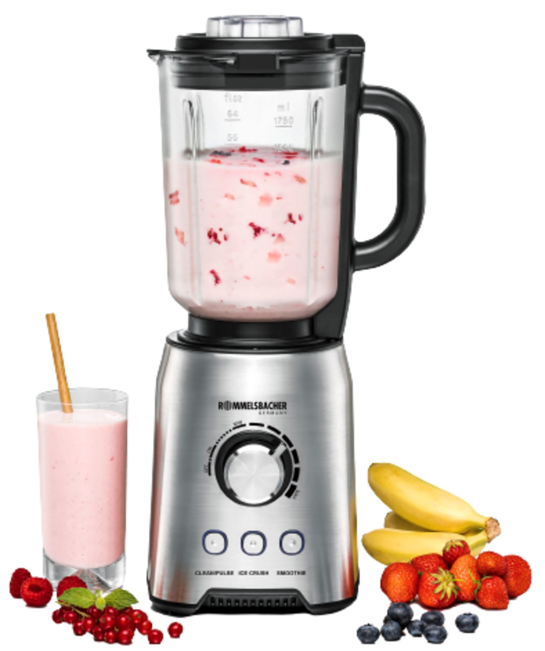 A silver blender with a glass of smoothie, berries, and bananas beside it.