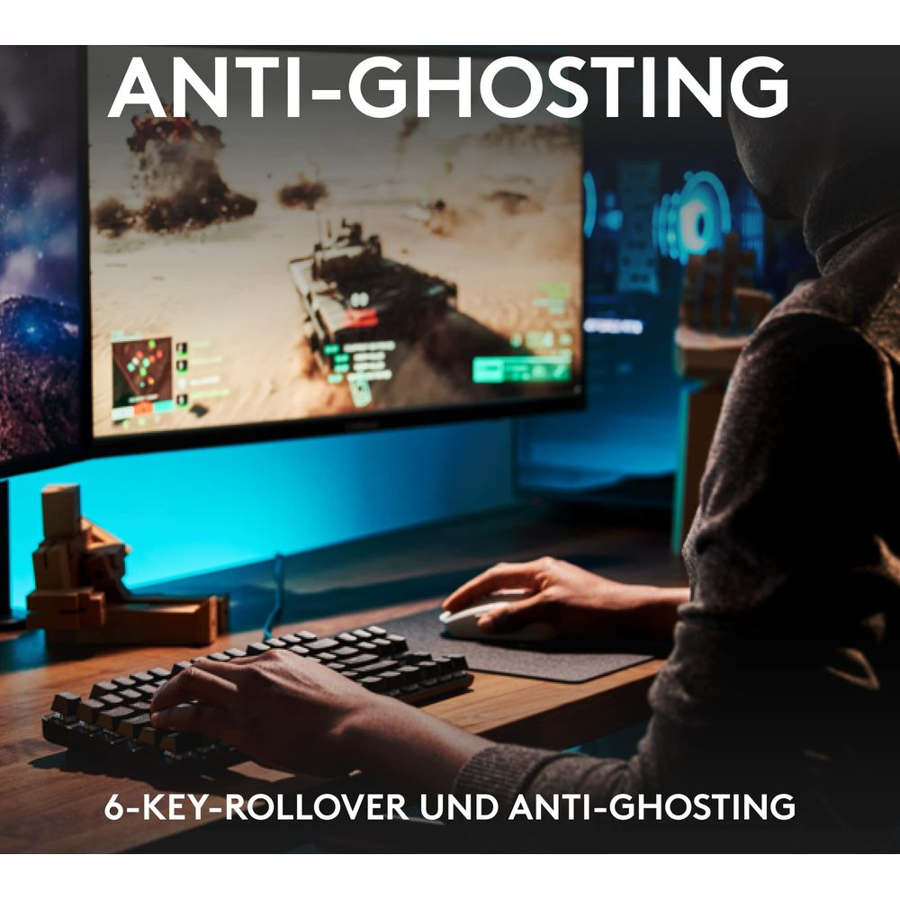 Gracz pisze na klawiaturze, gra w grę wideo na dwóch monitorach. Tekst: ANTI-GHOSTING.