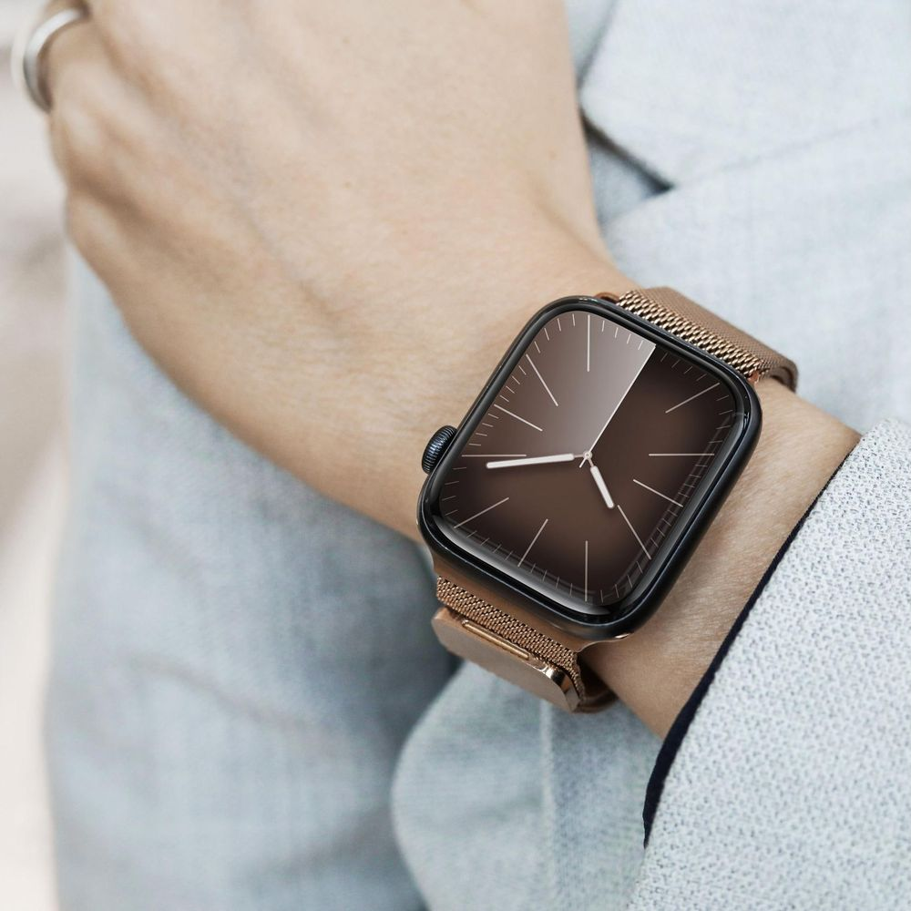 Zegarek na nadgarstku z brązową tarczą i bransoletą w kolorze różowego złota.