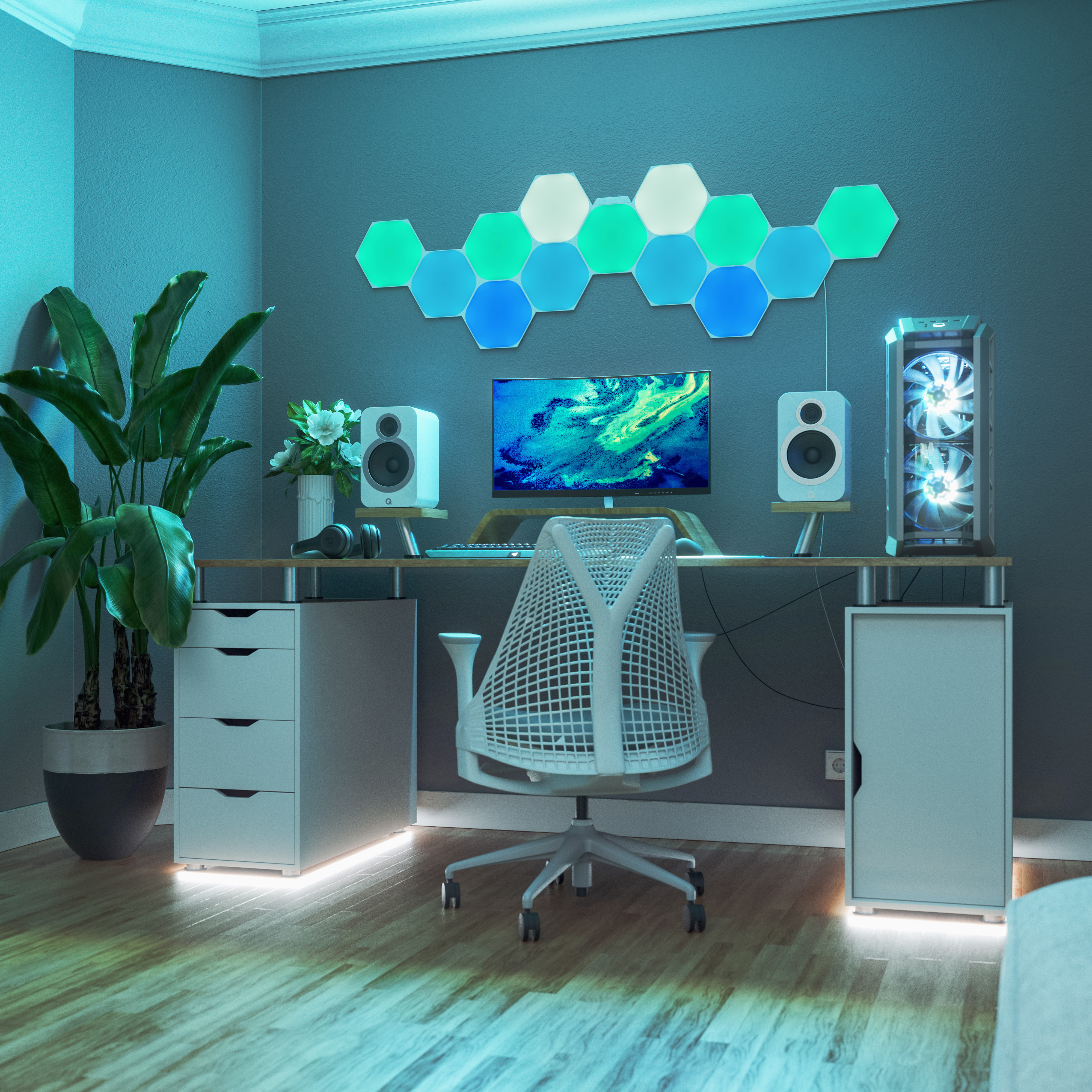 Ein Schreibtisch mit Gaming-PC, Monitor, Lautsprechern und einer Pflanze.