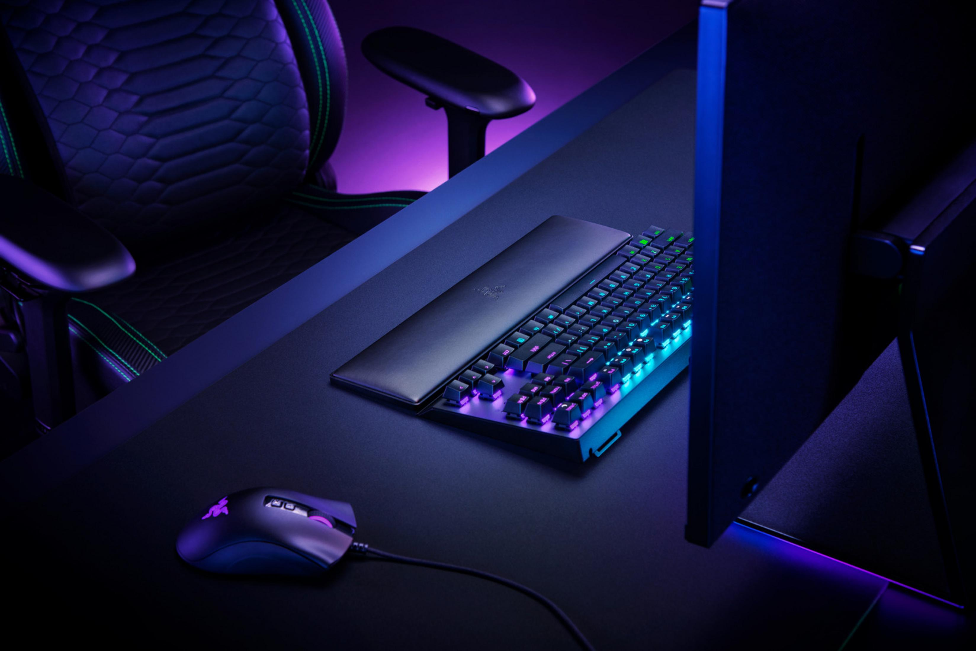 Un fauteuil gamer, clavier et souris dans le noir, avec éclairage RVB.