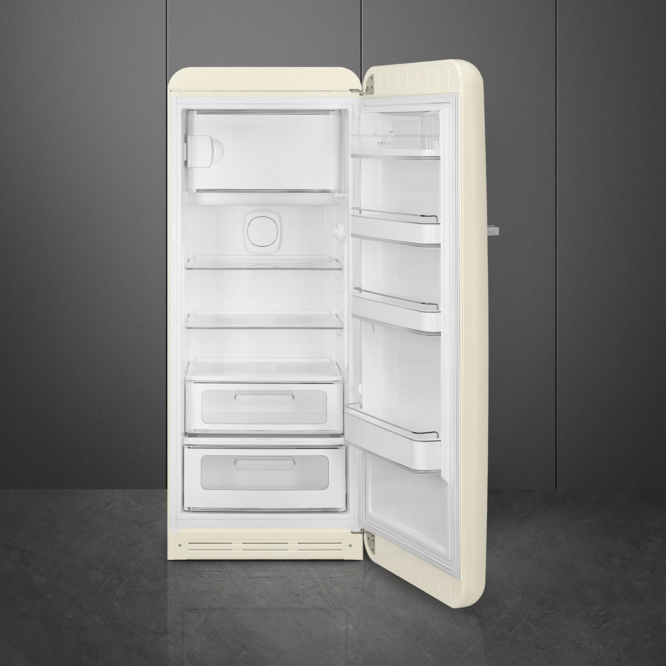Ein offener cremefarbener Kühlschrank mit weißen Einlegeböden und Schubladen.