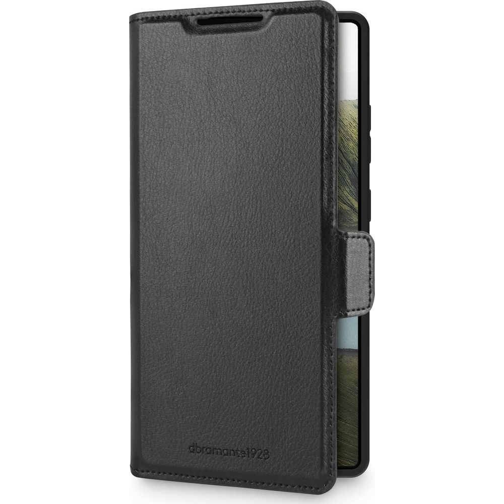 Una custodia a libro in pelle nera per telefono è mostrata chiusa, con una piccola linguetta che la fissa. Il telefono all'interno è parzialmente visibile.