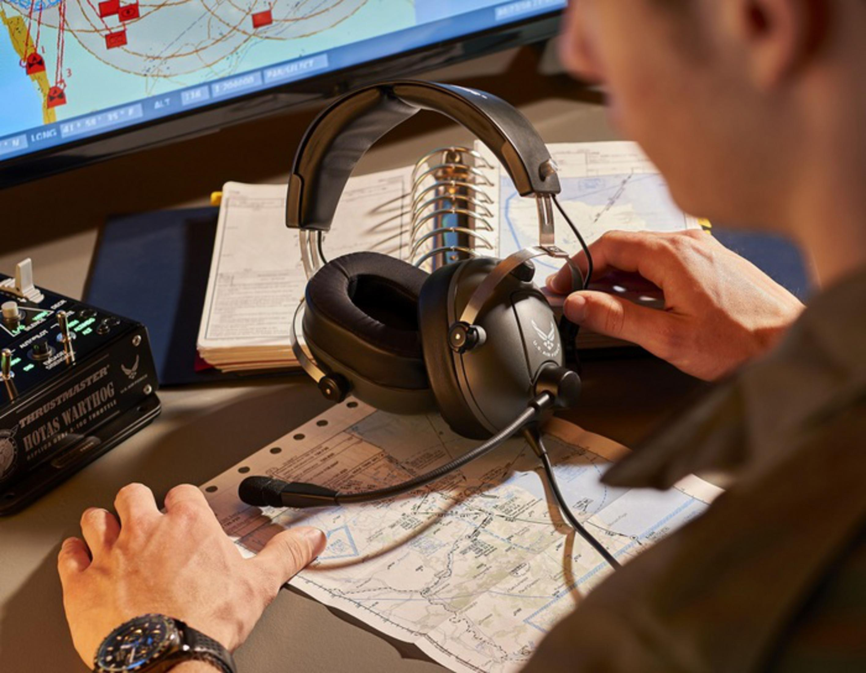 Osoba ze słuchawkami i mapą w kokpicie.