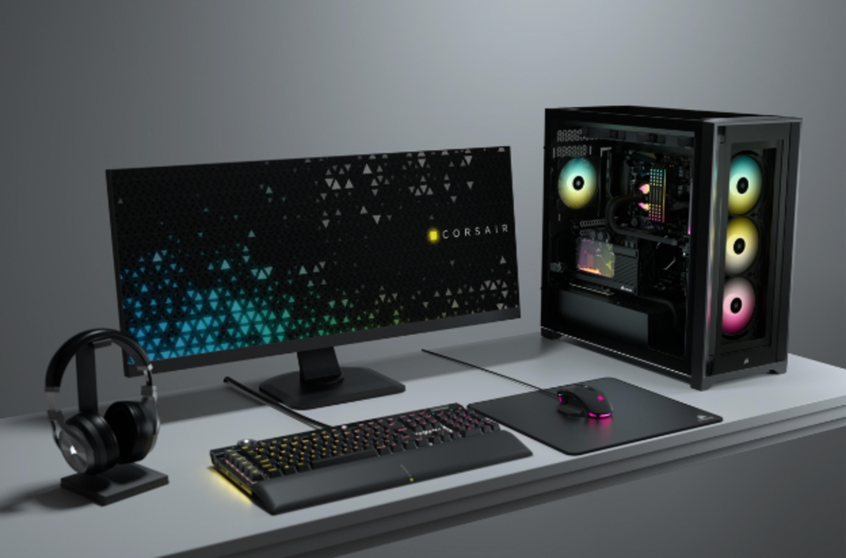 Czarny komputer gamingowy z wentylatorami RGB, monitorem, klawiaturą i myszką.