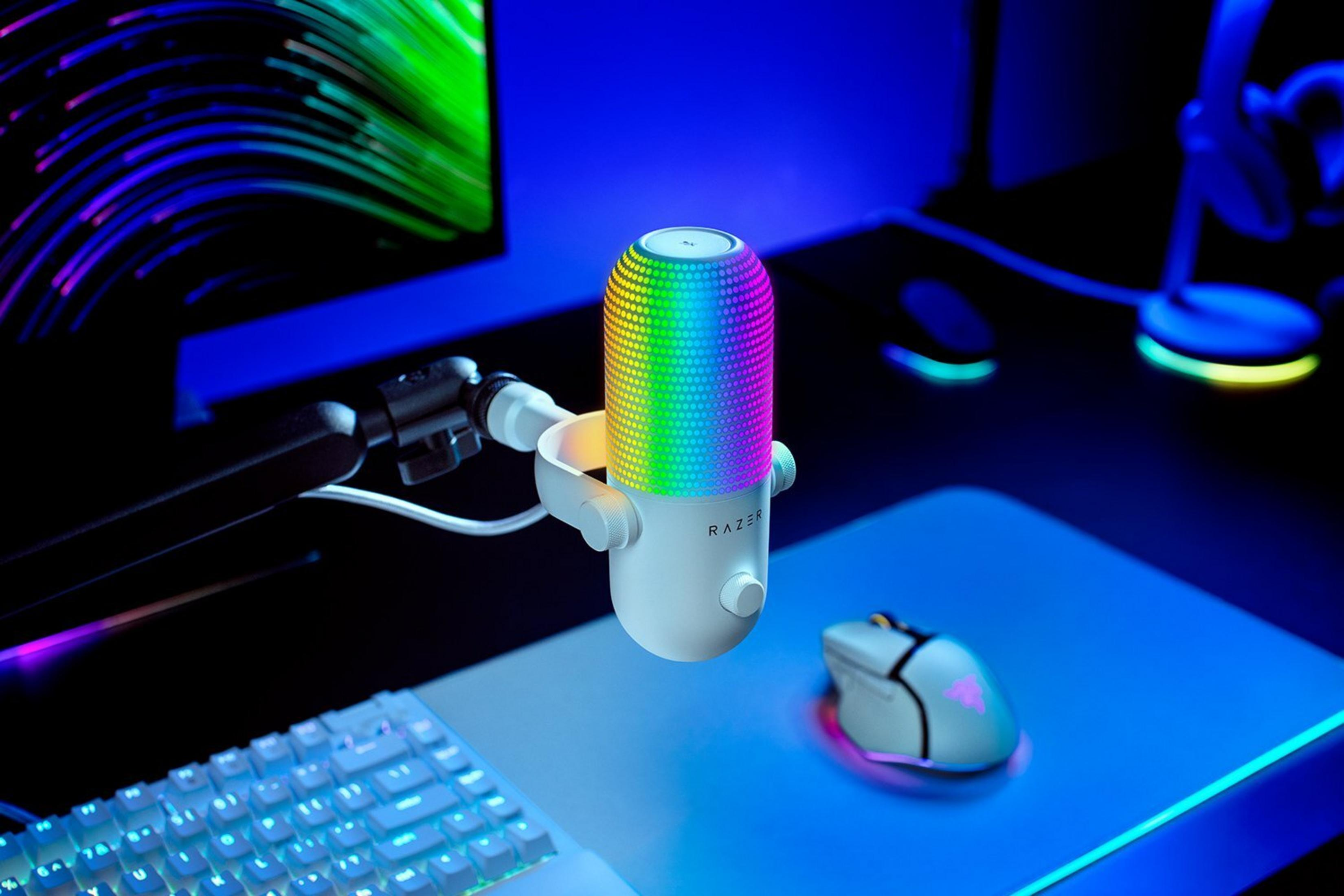 Ein weißes Razer-Mikrofon mit RGB-Beleuchtung steht auf einem Schreibtisch neben einer Tastatur und Maus.