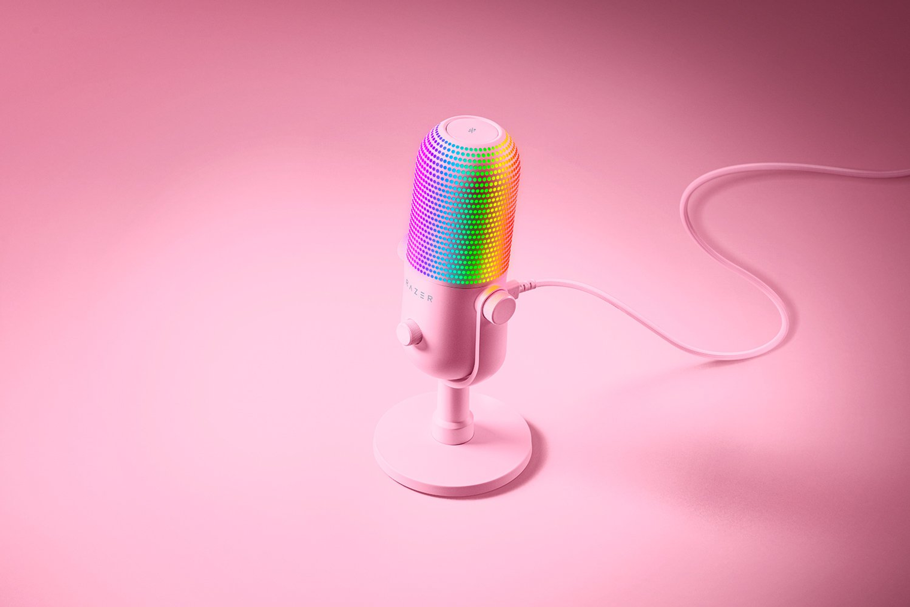 Ein pinkes Mikrofon mit RGB-Beleuchtung auf einem Ständer auf rosa Hintergrund.