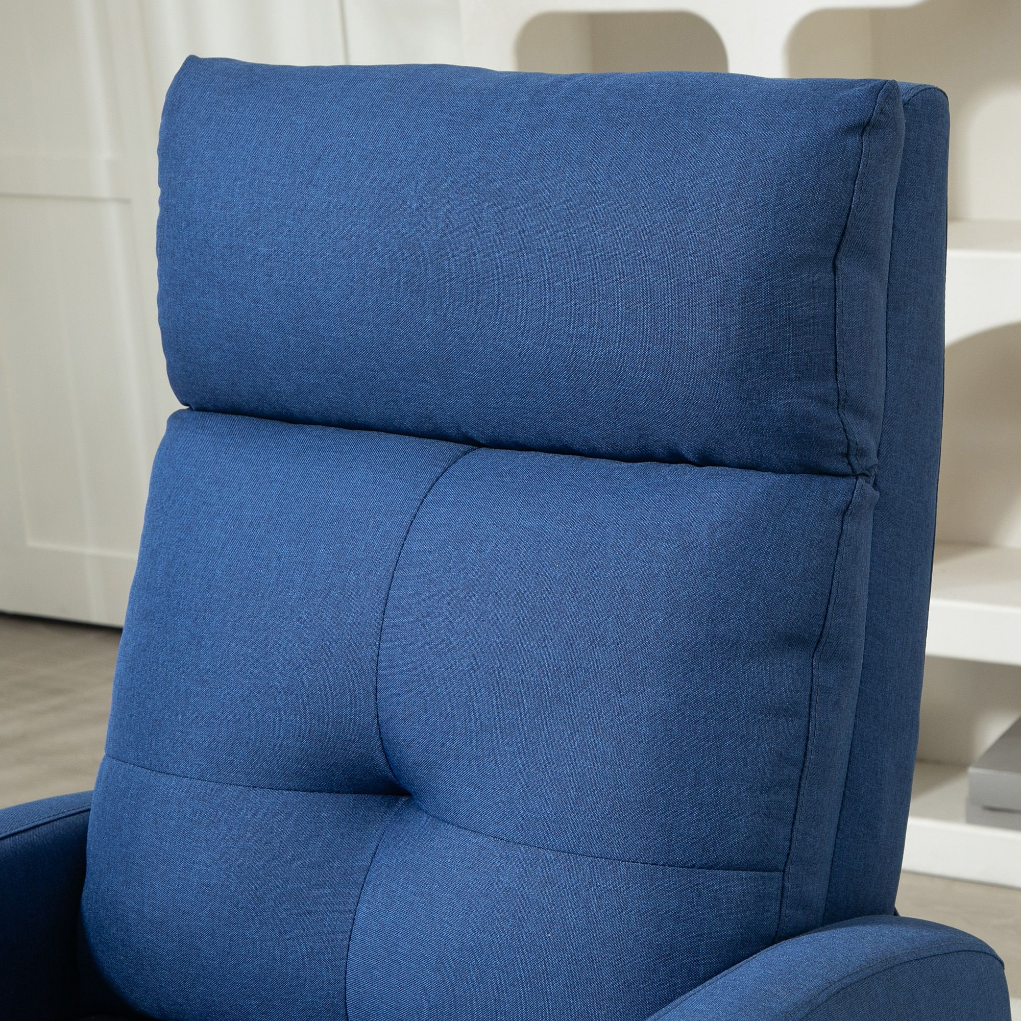 Un sillón azul con respaldo acolchado y reposacabezas.