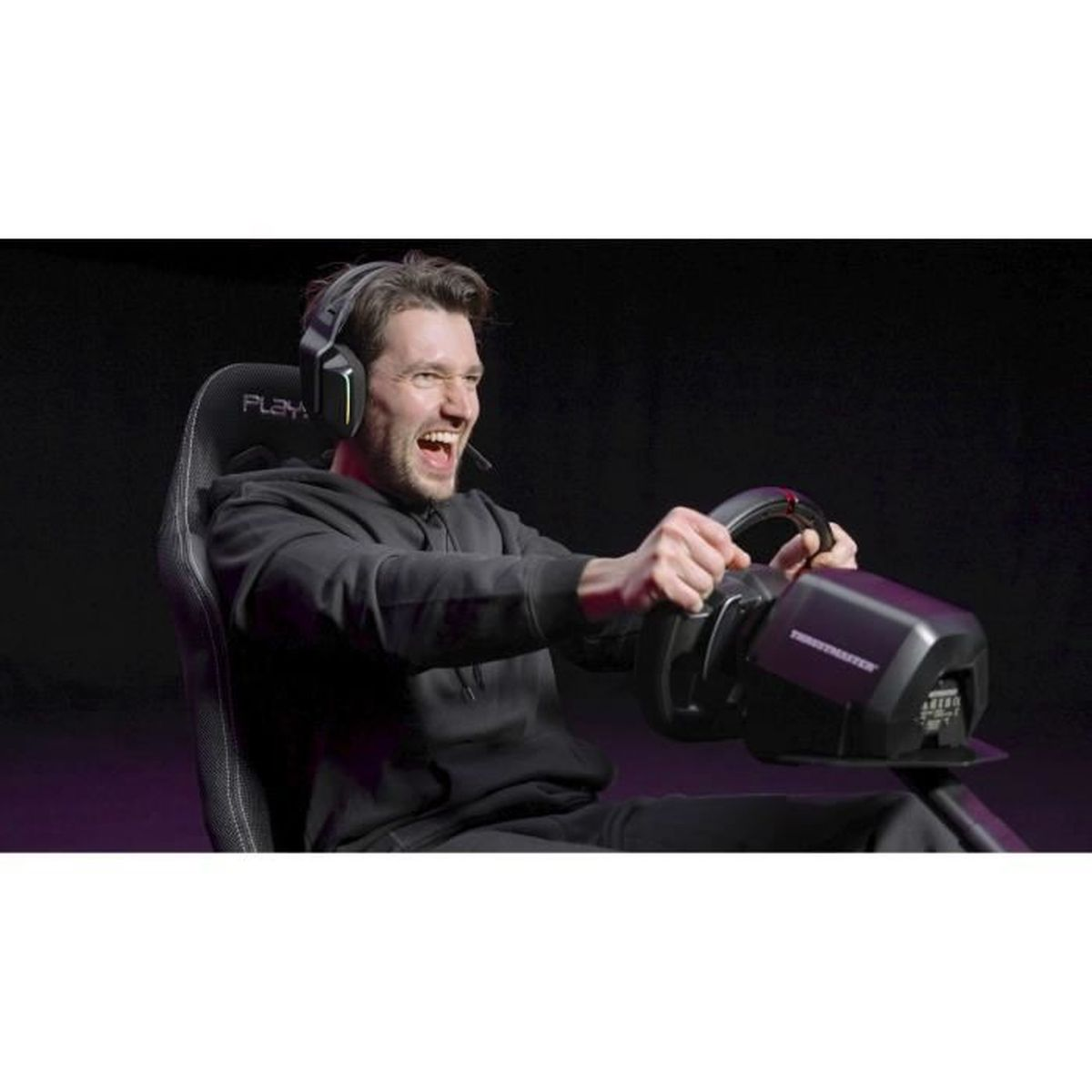 Homme portant un casque joue à un jeu de course dans un siège avec volant.