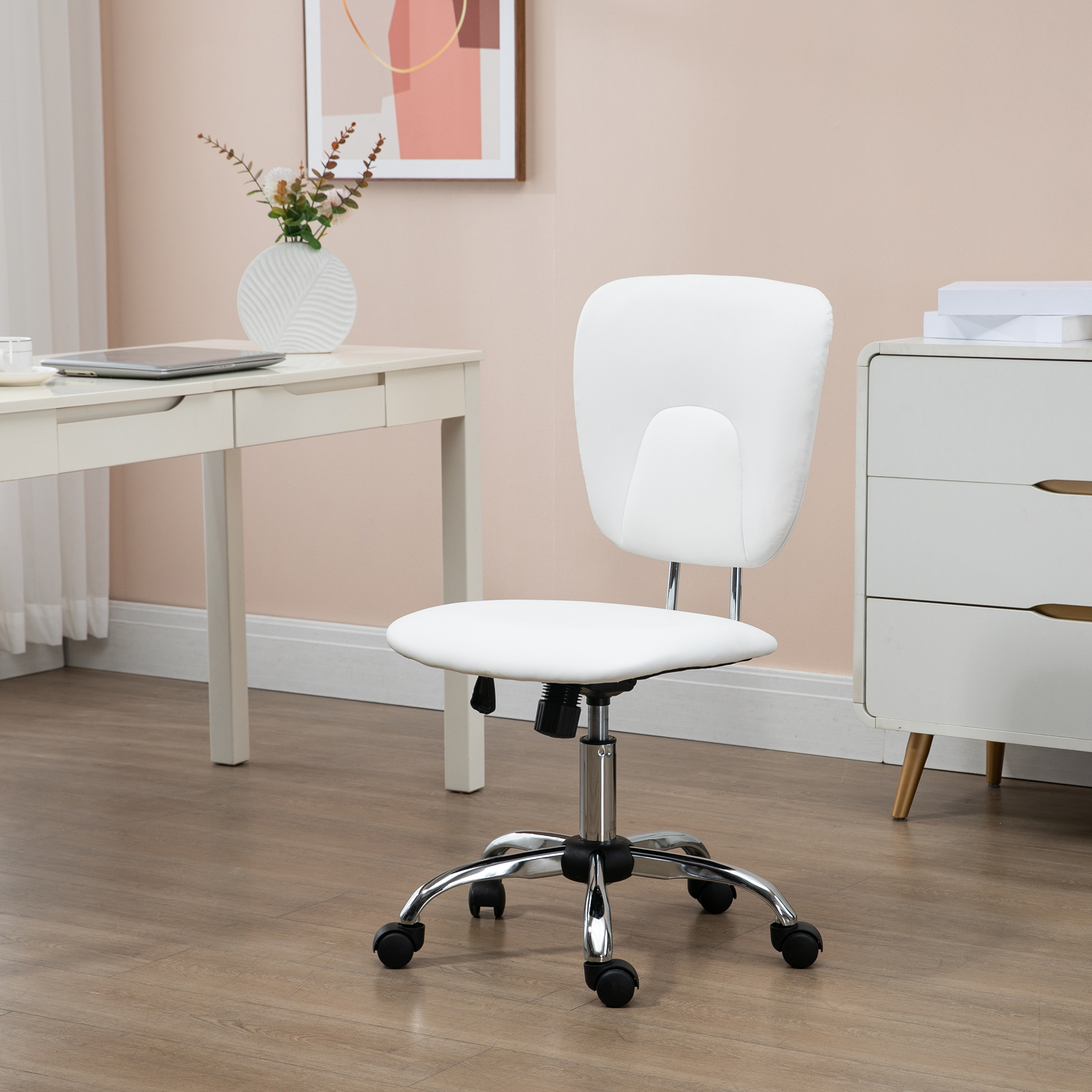 Una silla de oficina blanca con base cromada y ruedas está sobre un suelo de madera.