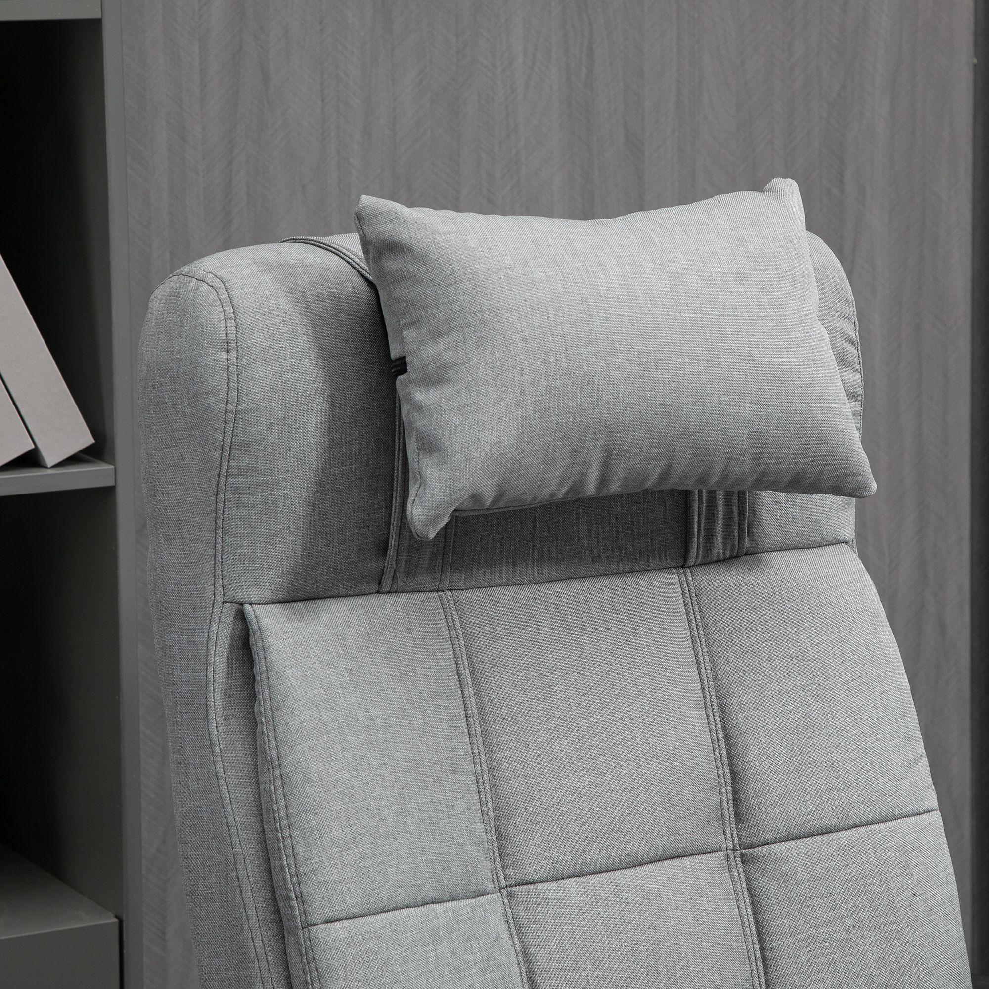 Silla de tela gris con reposacabezas ajustable y asiento acolchado.