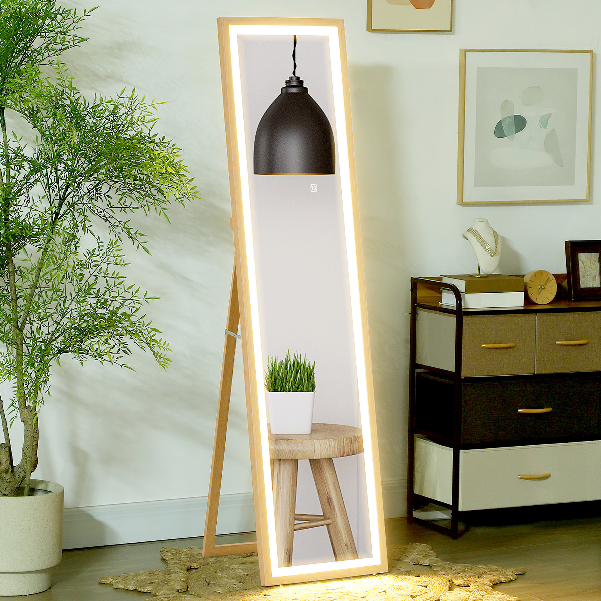 Un espejo con marco de madera y luces LED está junto a una planta.
