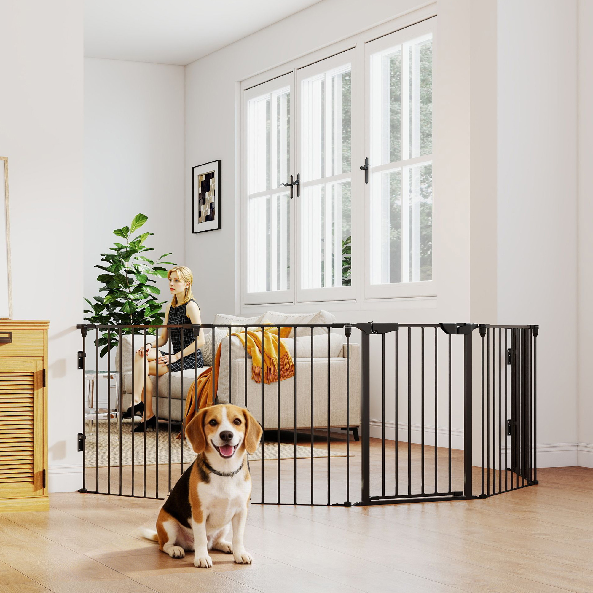 Un beagle se sienta frente a una puerta para mascotas negra en una sala. Una mujer se sienta en un sofá.