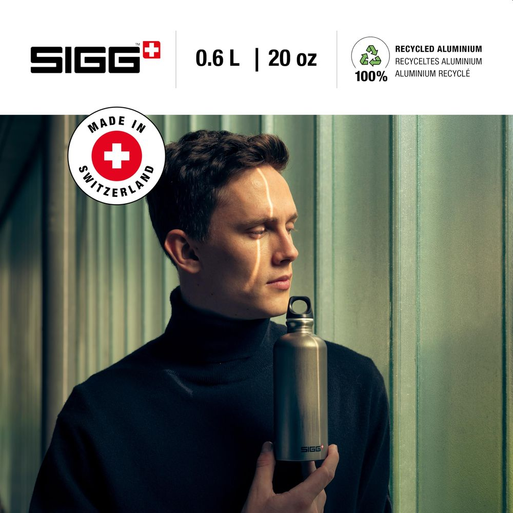 Ein Mann hält eine silberne SIGG-Flasche vor einem hellgrünen Hintergrund.