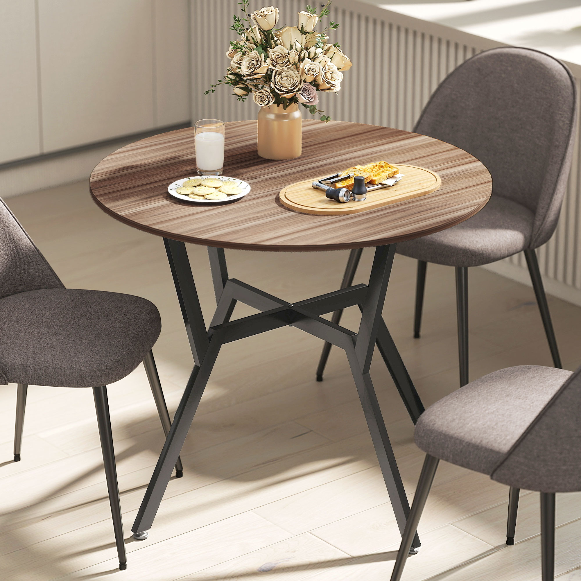 Una mesa redonda de madera con tres sillas, flores y comida.